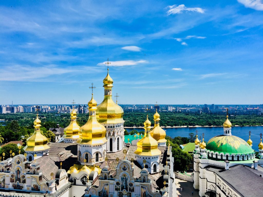 a large white and gold building with gold domes