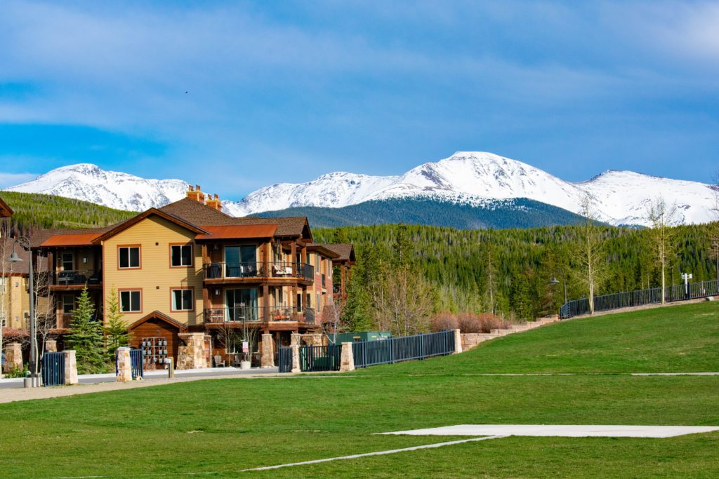 a building with a lawn and mountains in the background