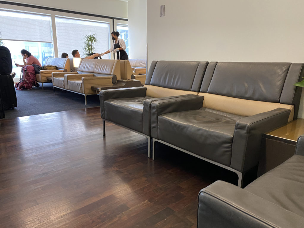 a group of people sitting in a room with leather couches