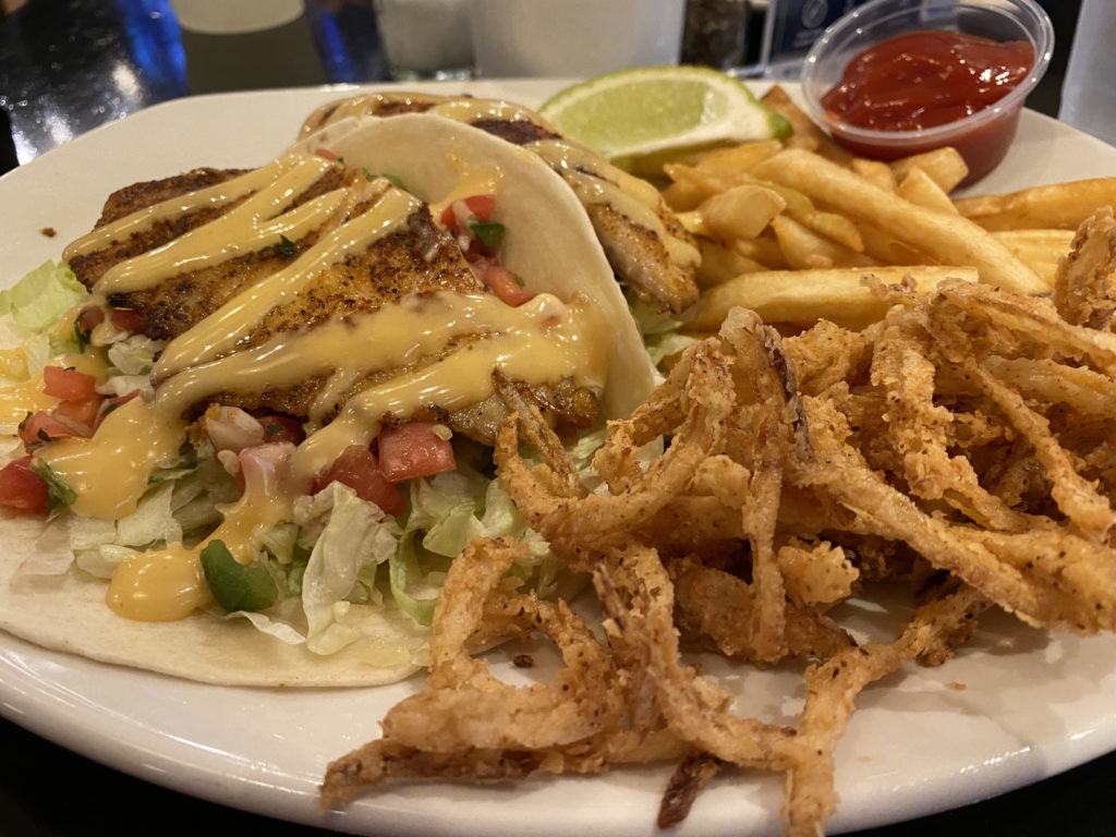 a plate of food with a taco and fries