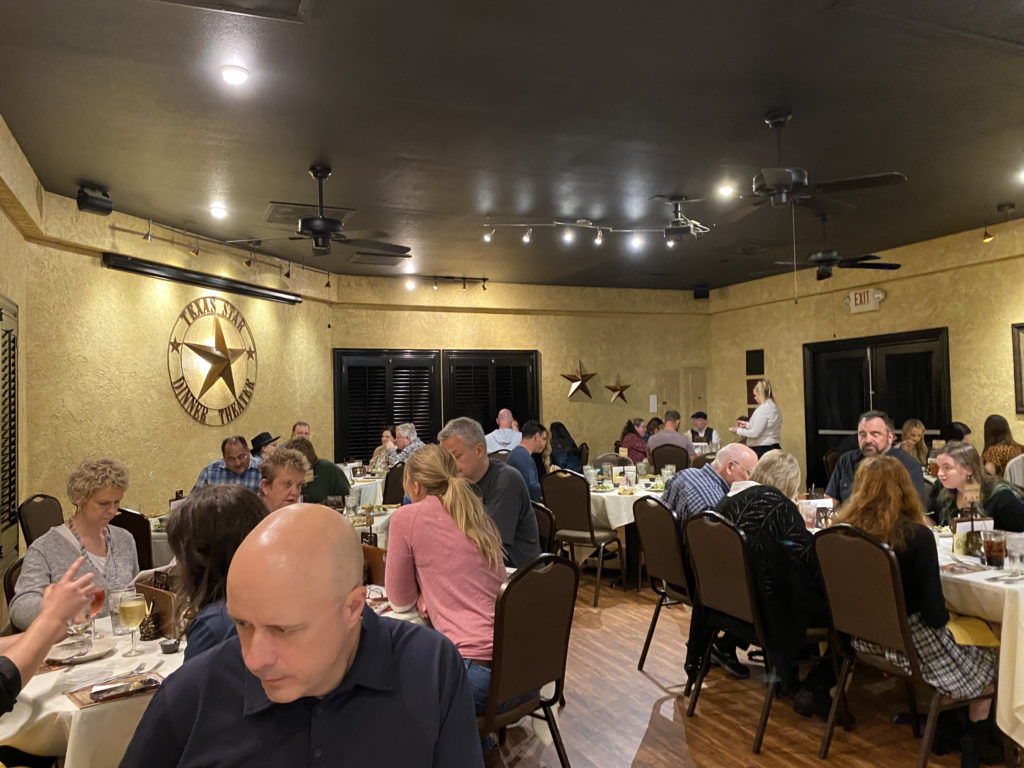 a group of people sitting at tables in a restaurant