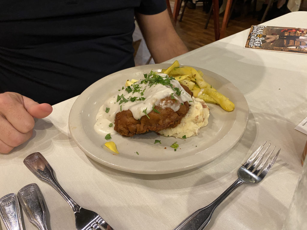 a plate of food with a person's hand