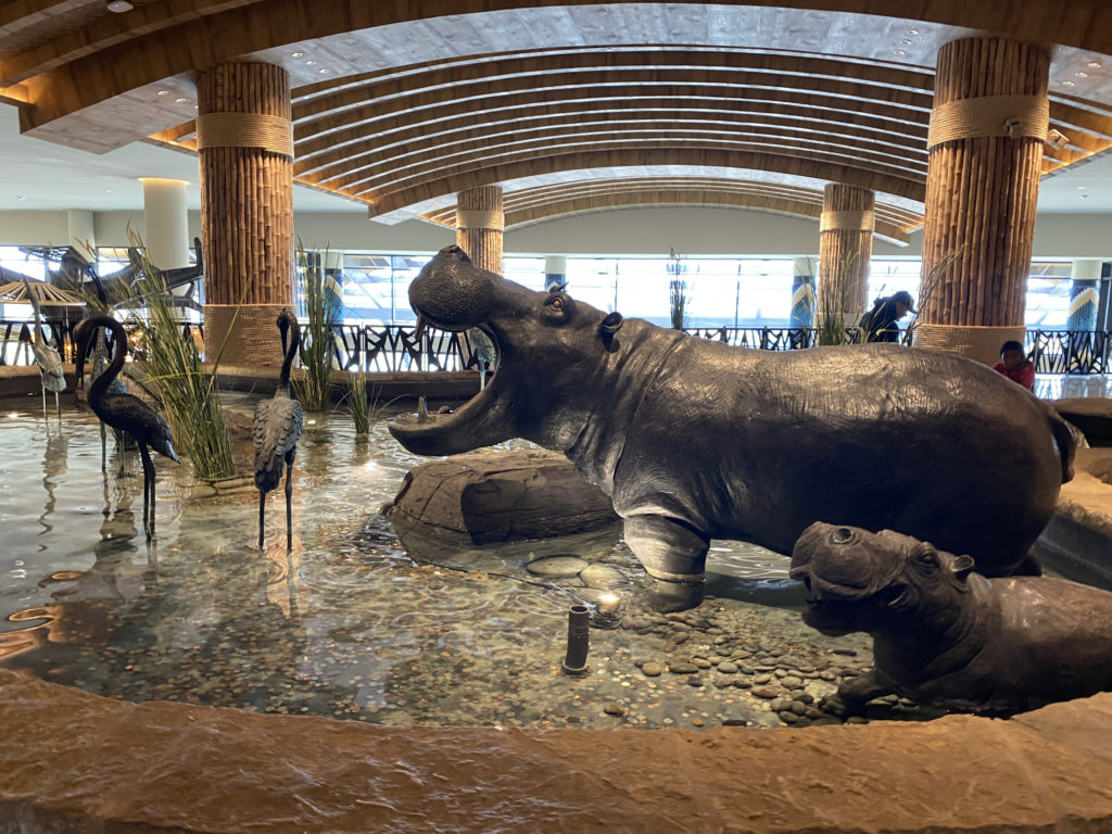 a statue of a hippo and a baby hippo in a pool of water