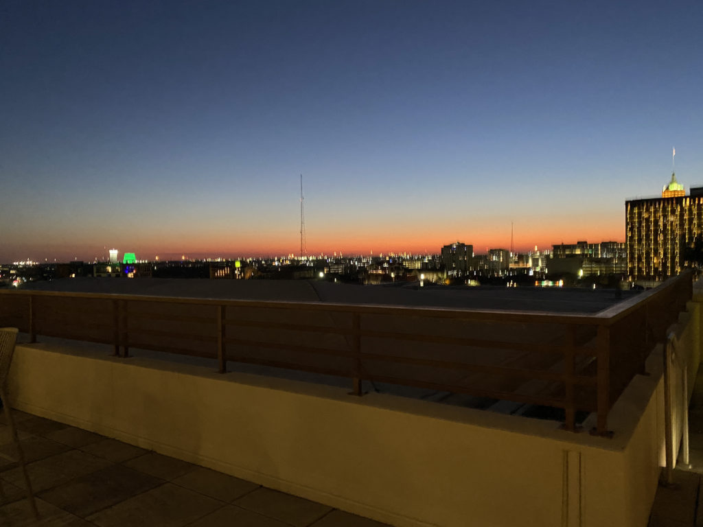 a rooftop with a city skyline at night