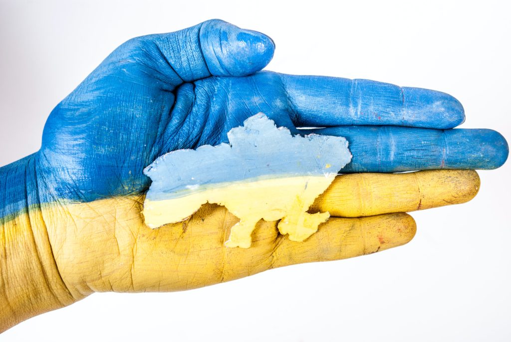 a hand with a blue and yellow paint on it