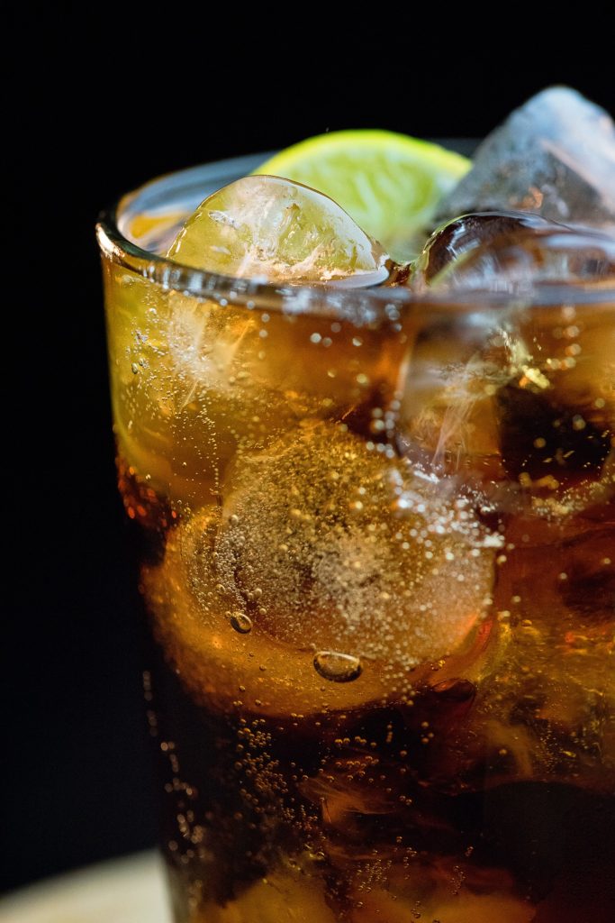 a glass of ice tea with ice and lime