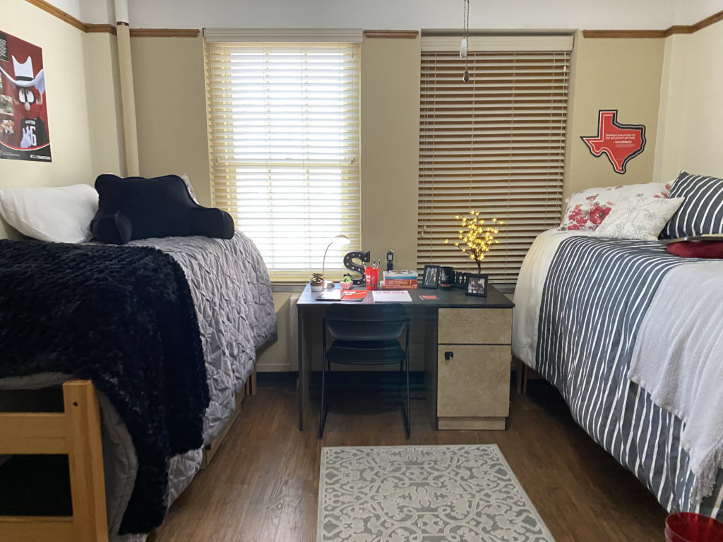 a room with two beds and a desk