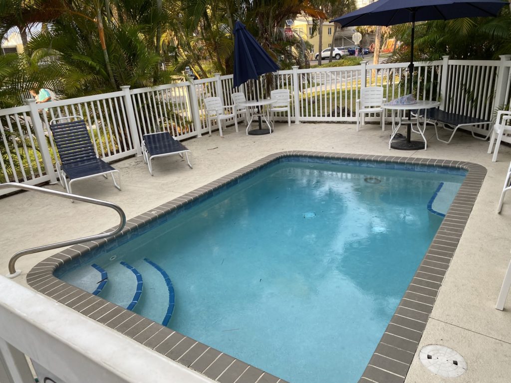 a pool with chairs and umbrellas on a deck
