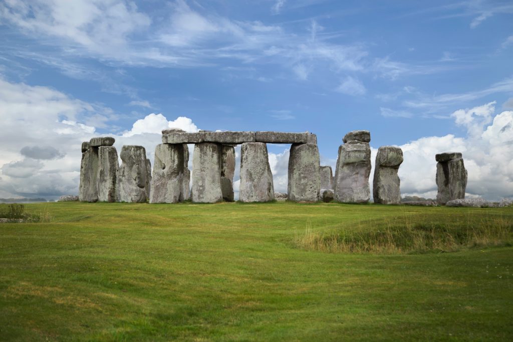 a stonehenge in a grassy field with Stonehenge in the background