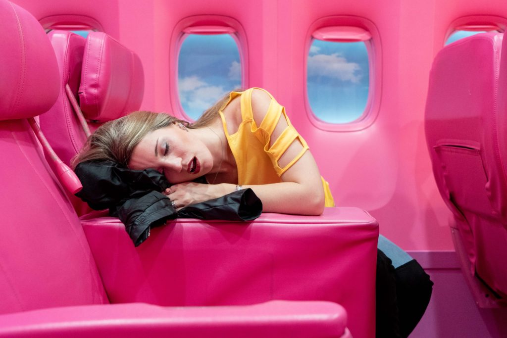 a woman sleeping on a pink chair