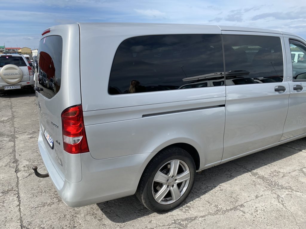 a silver van with a gas pump
