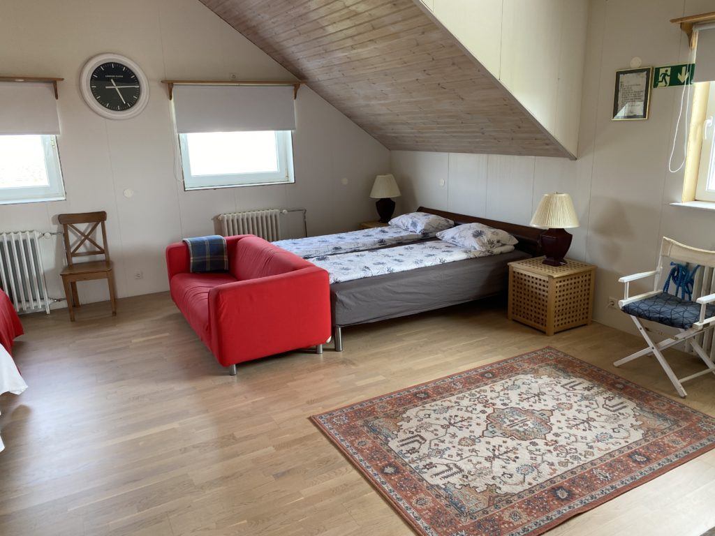 a bedroom with a red couch and a bed