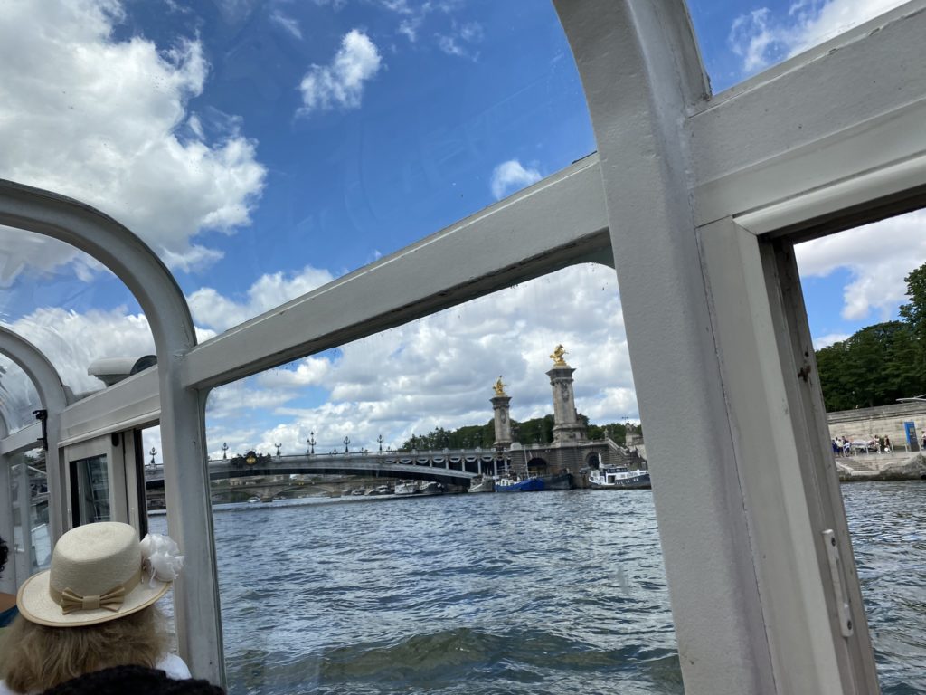a person in a hat looking out a window at a bridge