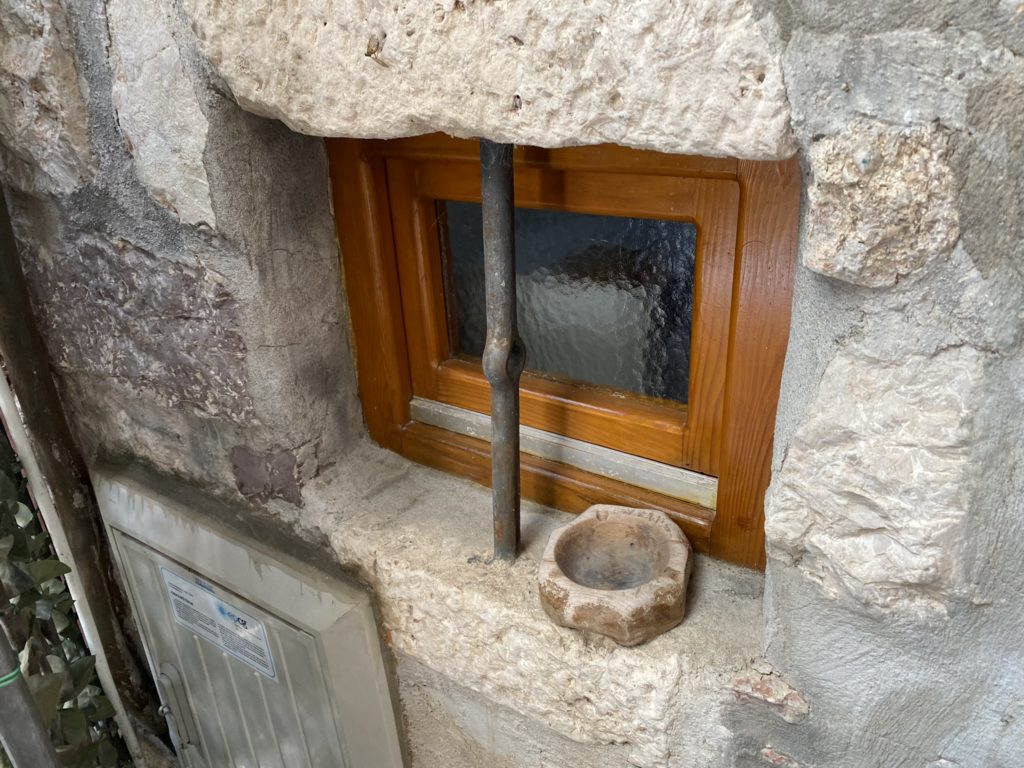 a window with a pipe and a stone wall