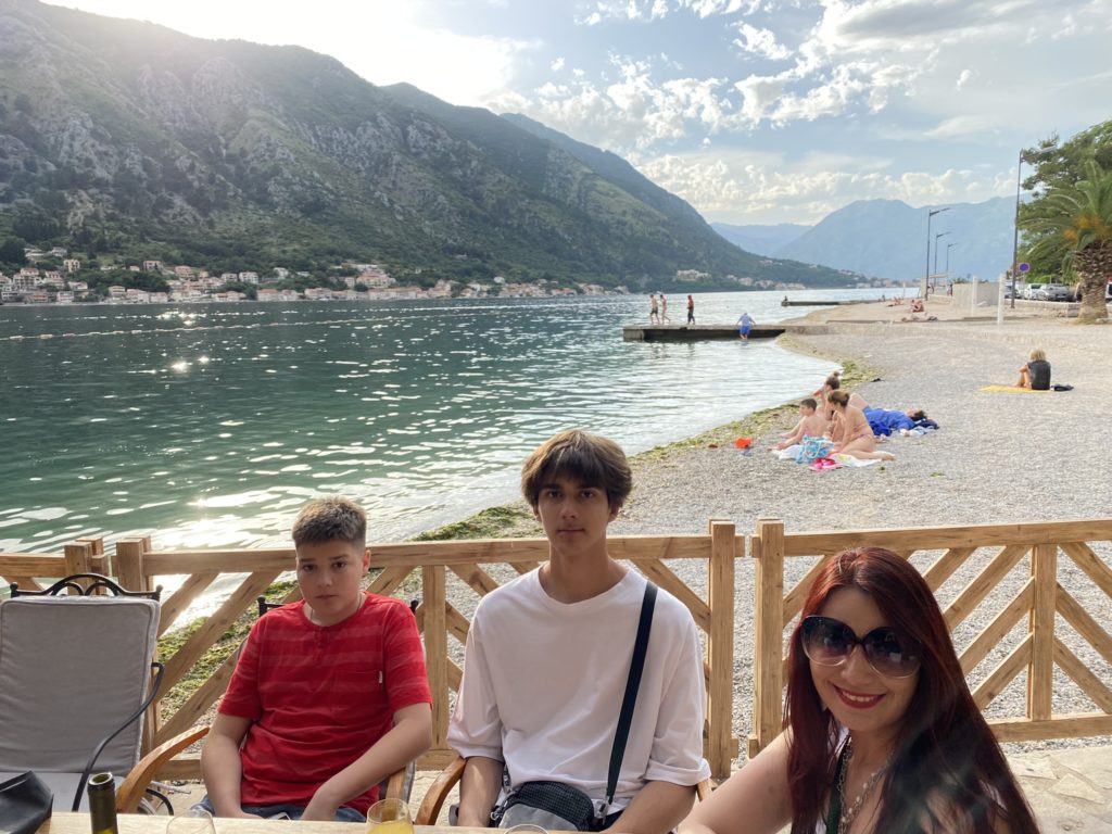 a group of people sitting on a bench by a body of water