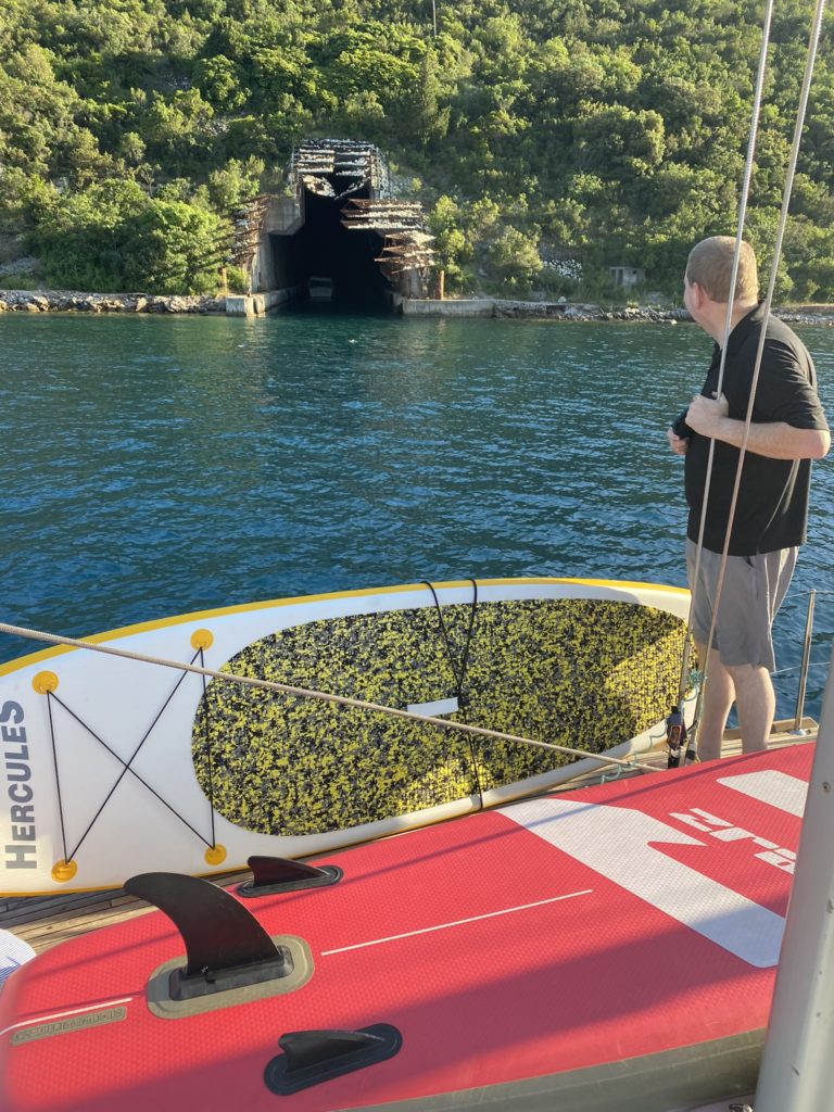 a man standing on a boat with a surfboard in the water
