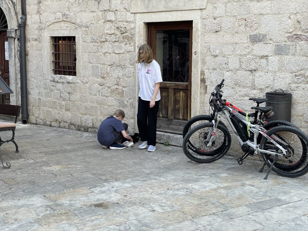 a woman and boy kneeling on the ground by bicycles
