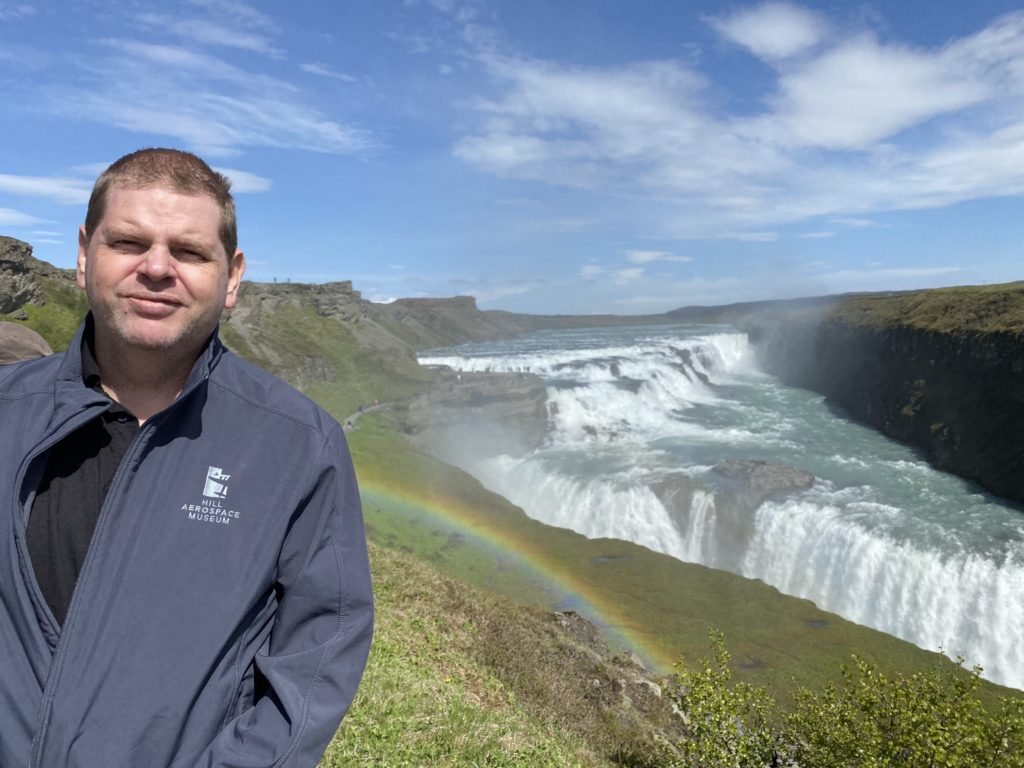 a man standing in front of a waterfall