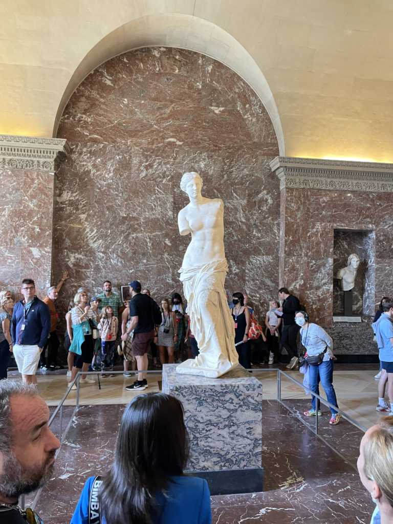 a group of people in a room with a statue