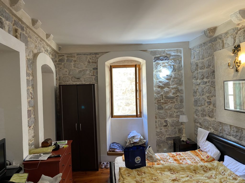 a bedroom with a stone wall and a bed