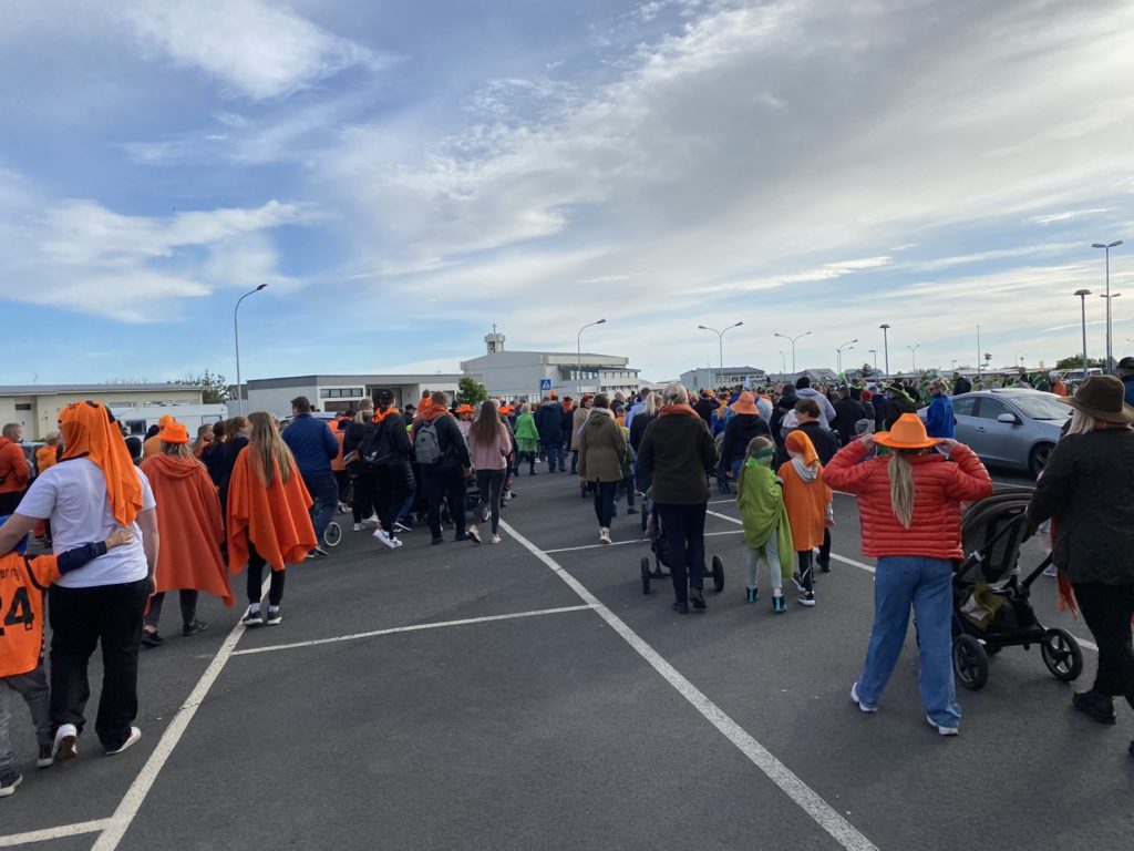 a group of people walking in a parking lot