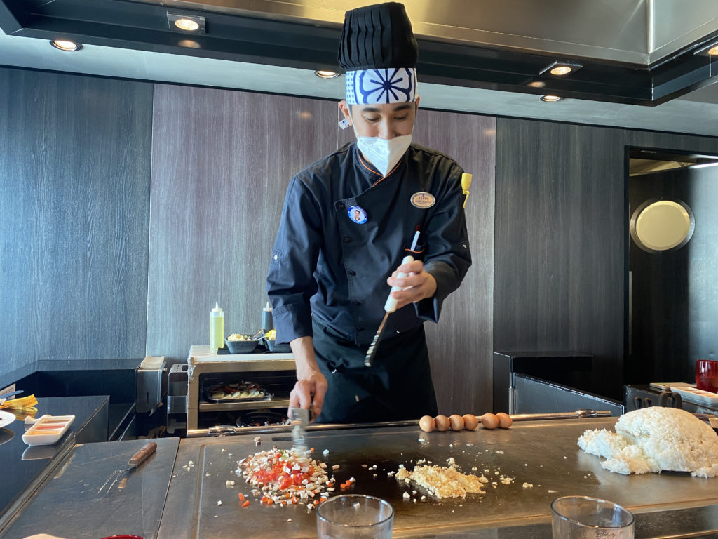 a man wearing a mask and cooking food