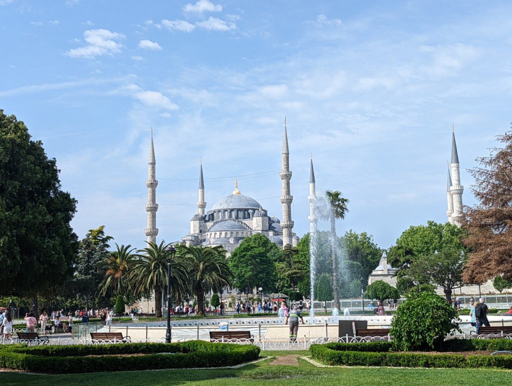 a large building with towers and a fountain in front of it