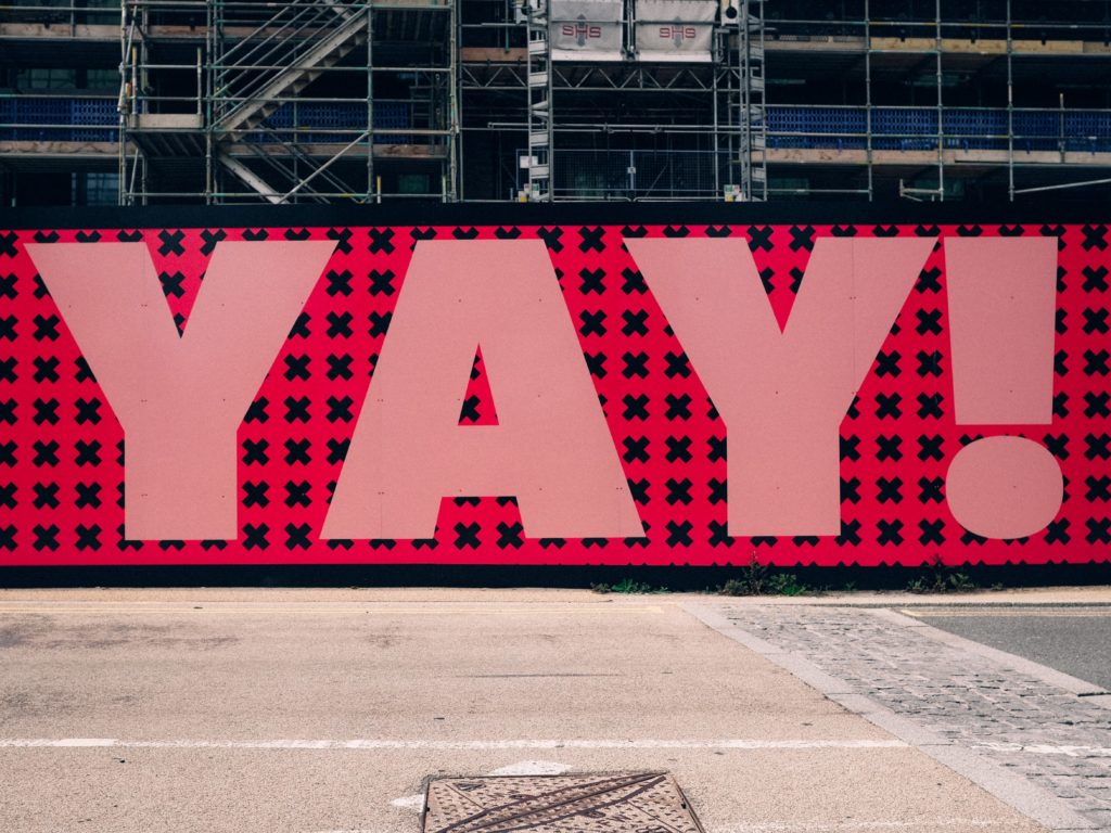 a large pink sign with black xs and red xs on it