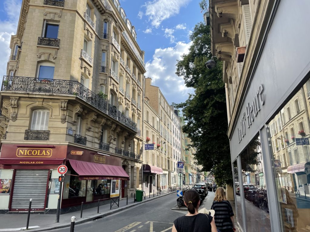 a woman walking down a street with buildings and a woman walking down a street
