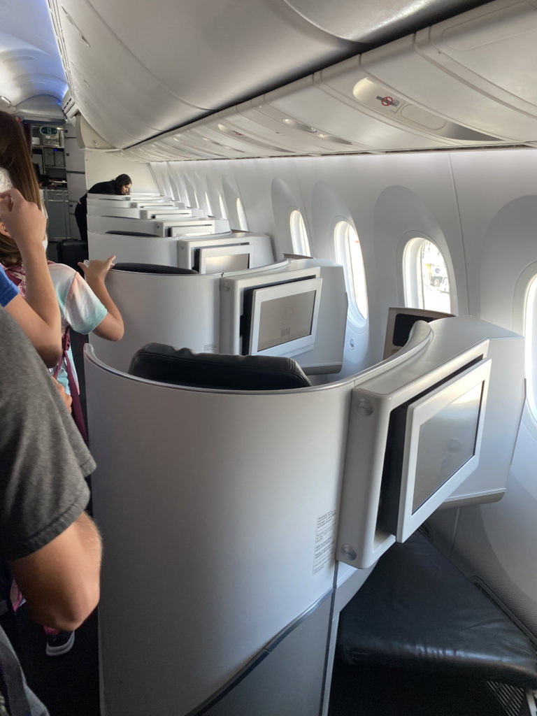 people in an airplane with a row of monitors