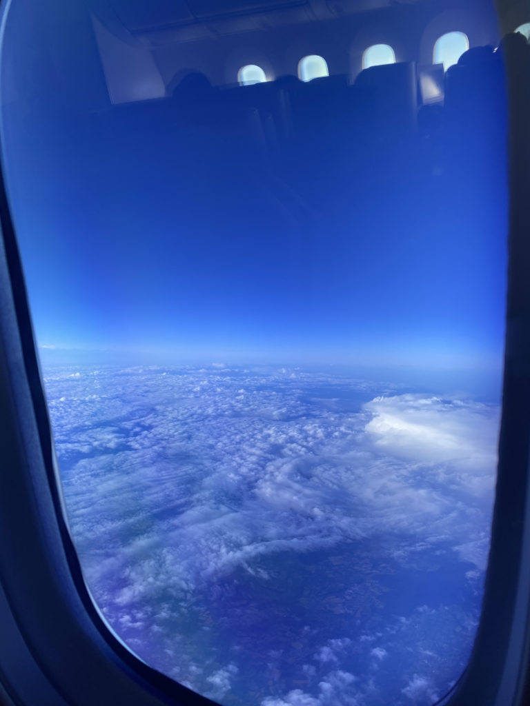 a view of clouds and blue sky from an airplane window
