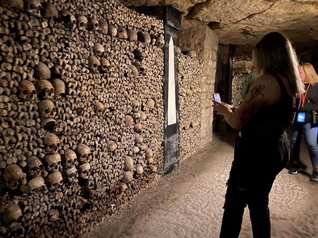 a woman standing in a room with skulls