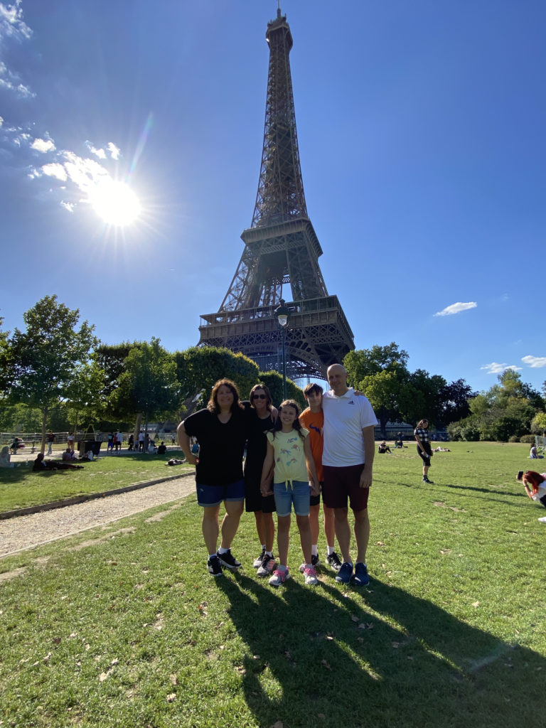 a group of people posing for a picture in front of the eiffel tower