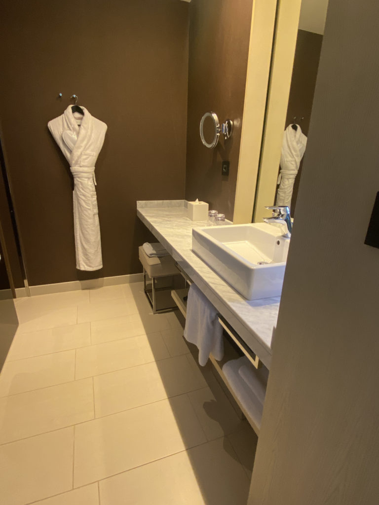 a bathroom with a white robe and sink