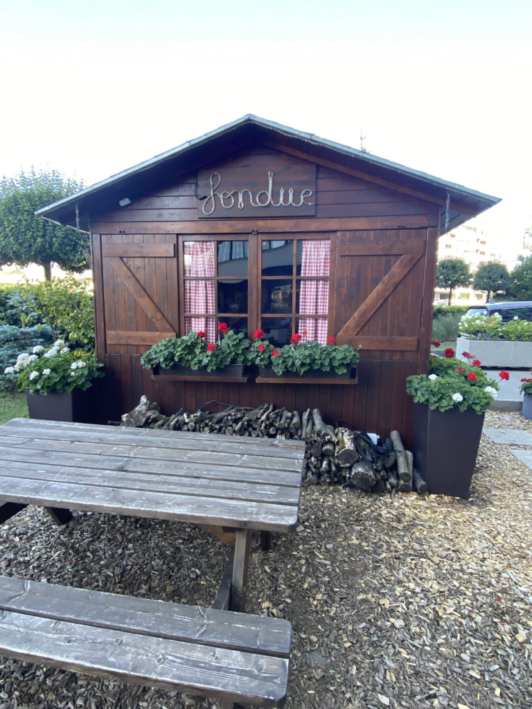 a small wooden building with a picnic table and a bench