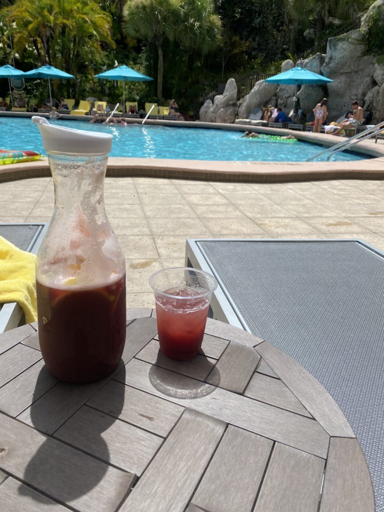 a drink and a drink on a table by a pool
