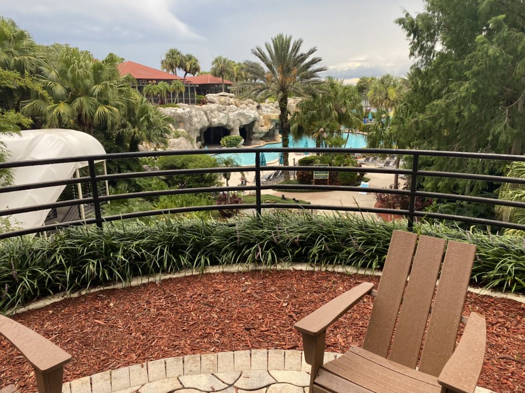 a deck with chairs and a pool in the background