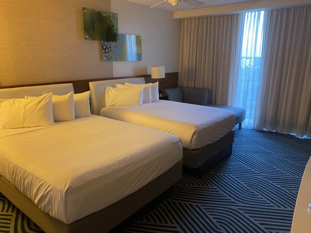 a room with two beds and a fan