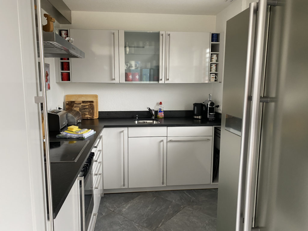 a kitchen with white cabinets and black counter tops