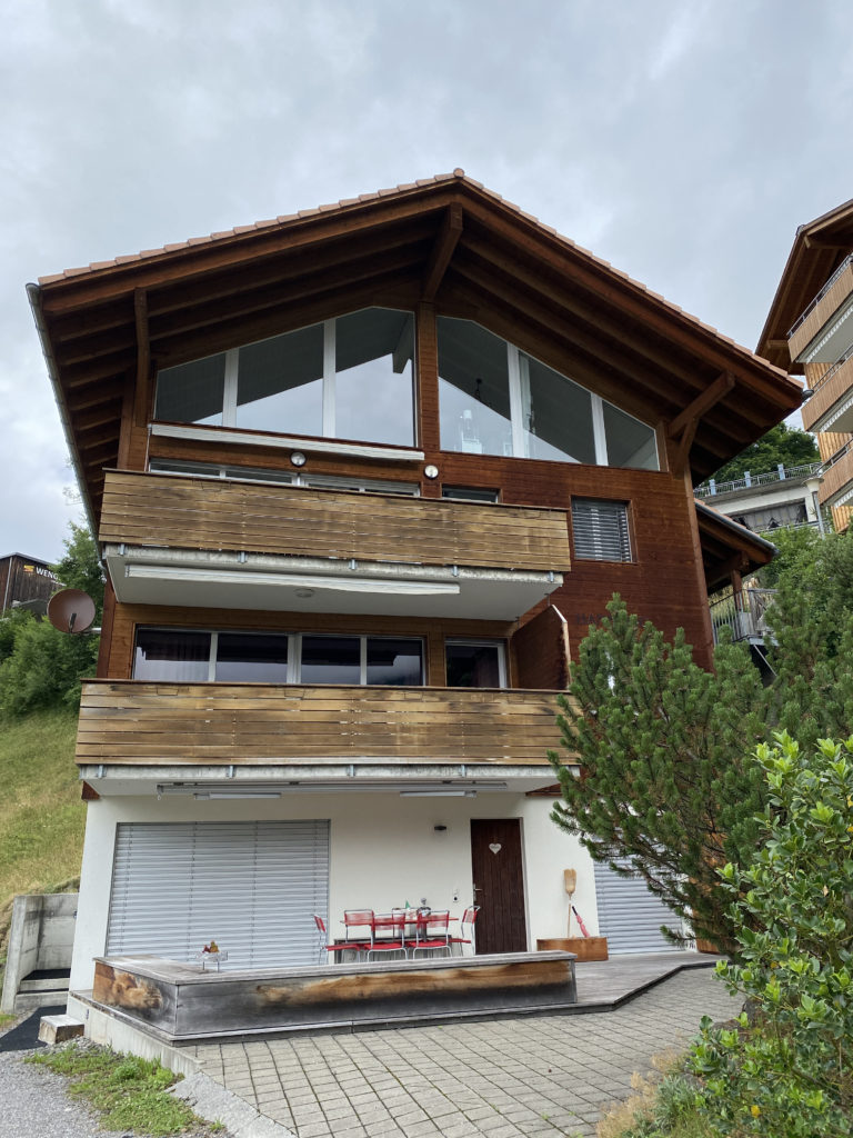 a building with a balcony and trees