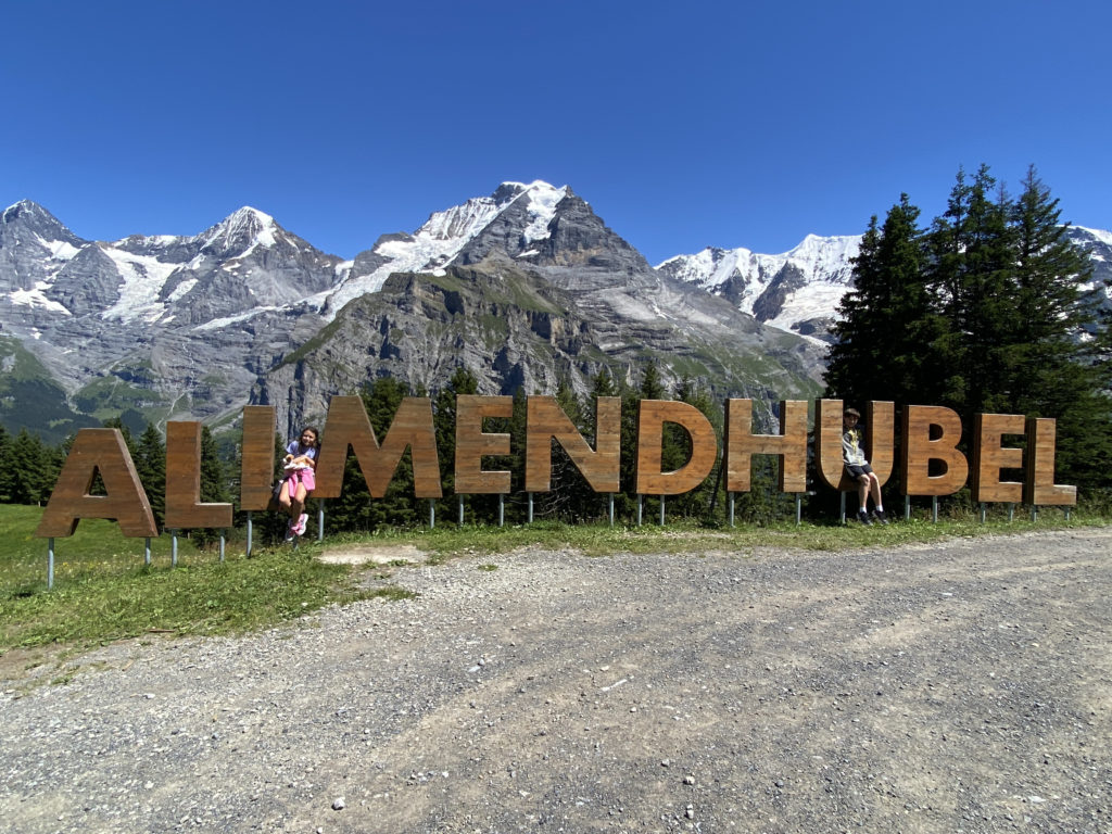 a sign with snow covered mountains in the background