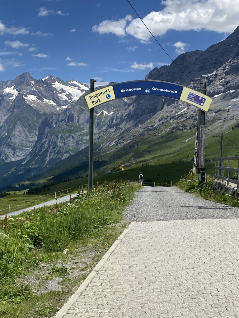 a sign on a road with mountains in the background