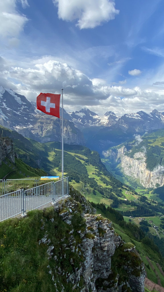 a flag on a pole with a mountain range in the background