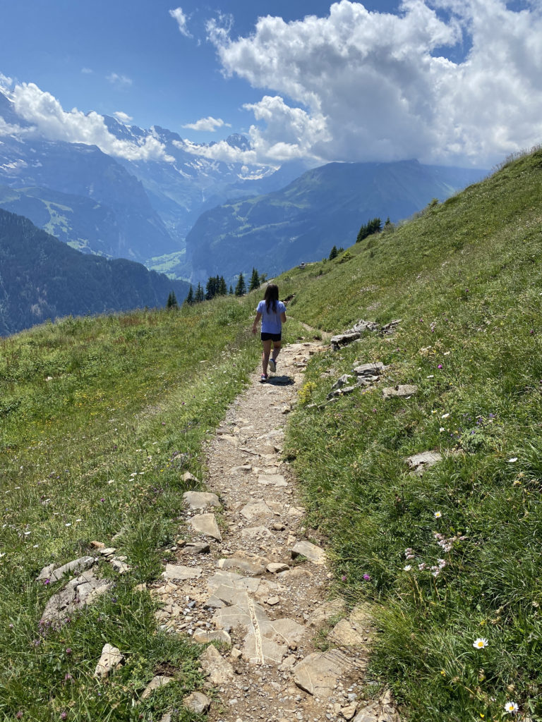 a girl walking on a path on a mountain