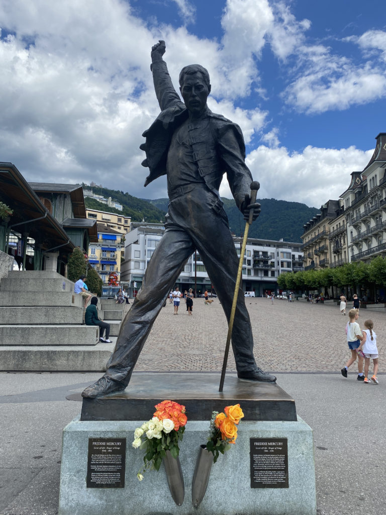 a statue of a man holding a cane and flowers