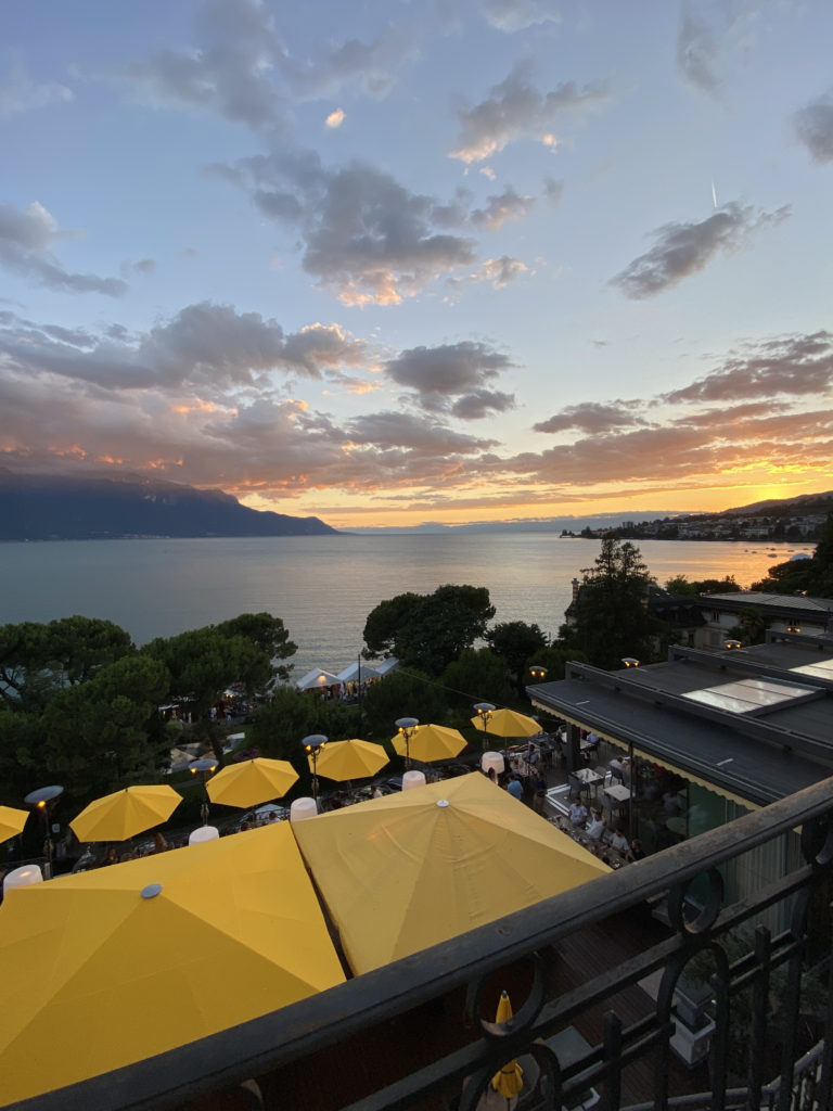a view of a lake from a balcony with a group of yellow umbrellas