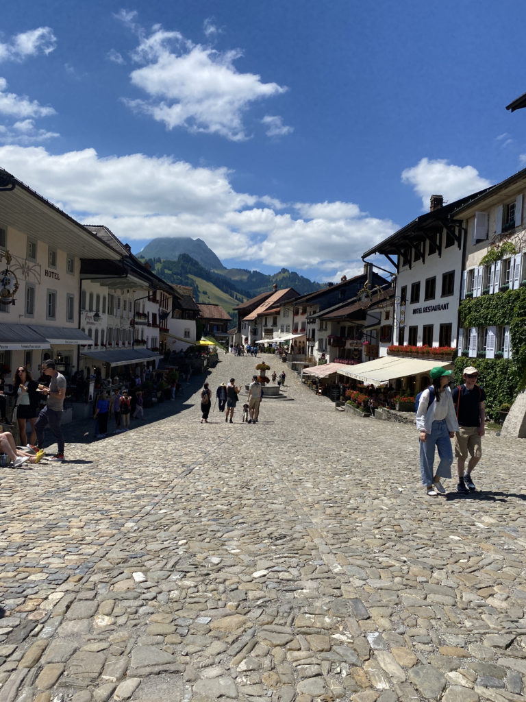 a stone street with buildings and people on it with Old Trail Town in the background