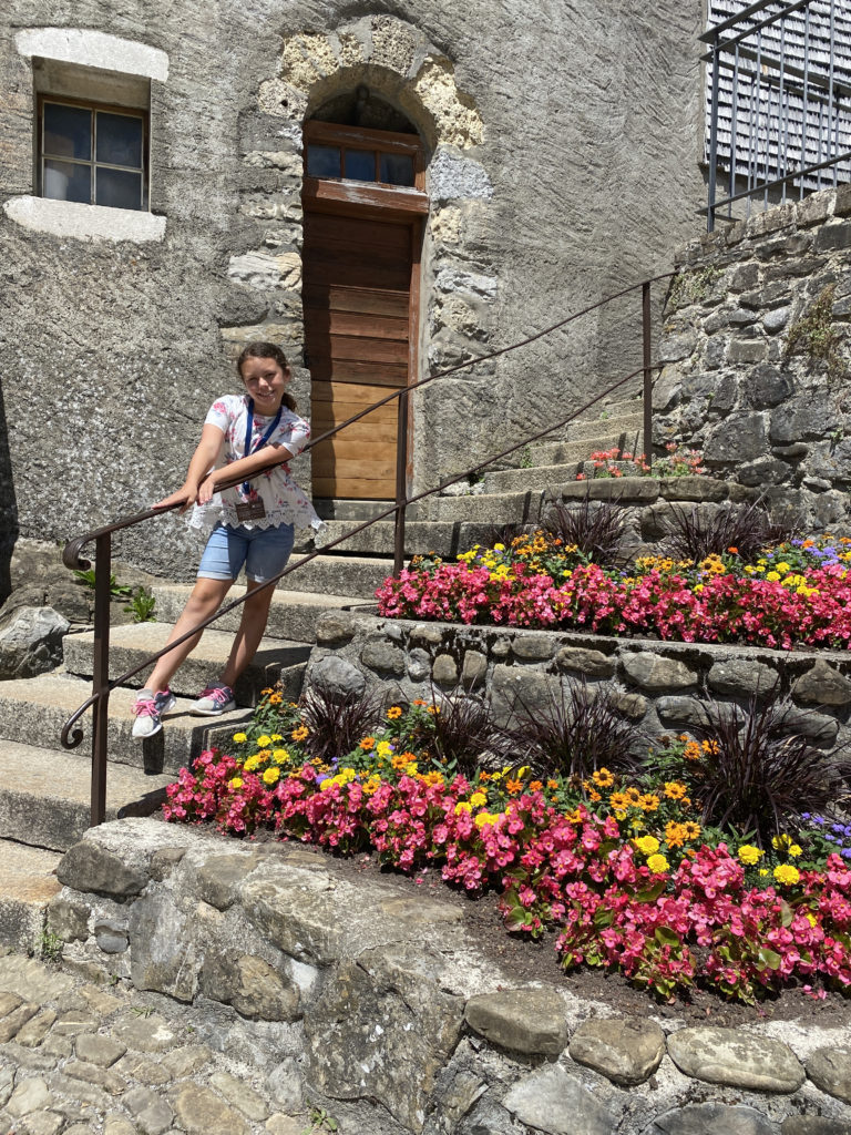 a woman standing on a stone staircase with flowers