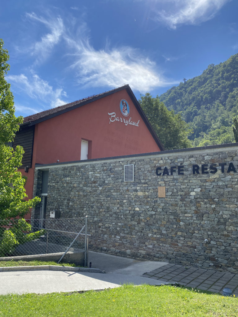 a building with a stone wall and a fence
