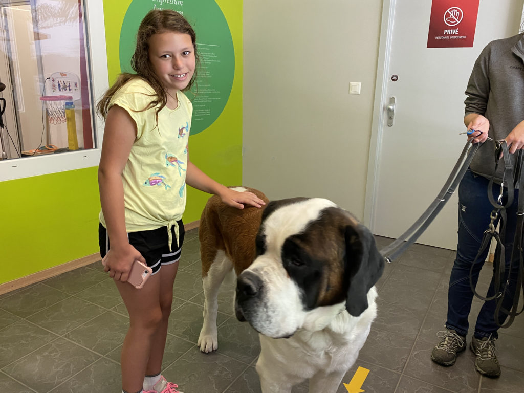 a girl standing next to a dog